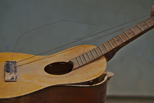 A closeup of a broken acoustic guitar