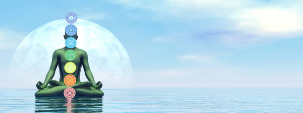istock Man meditating upon the ocean and chakra colors - 3D render 1439185488