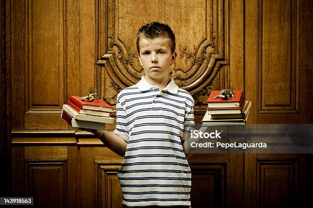 School Boy Castigados Sosteniendo Libros Foto de stock y más banco de imágenes de Incómodo - Incómodo, Travesura, Edificio escolar