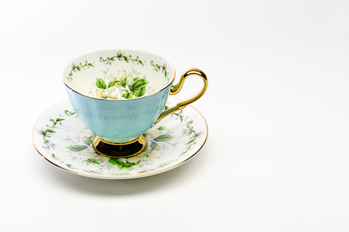 turquoise blue, inside flower-patterned china porcelain single teacup on a white background