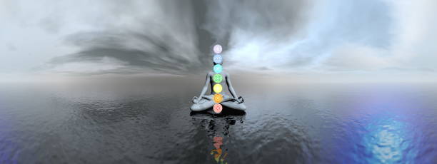 istock Man meditating upon the ocean and chakra colors - 3D render 1439192610