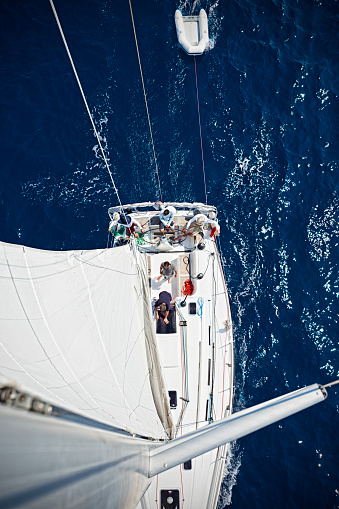 Sailboat from above. Sailing crew of three people on sailboat sailing. High angle view from top of mast. All 3 people model released. Canon 5DMkII.