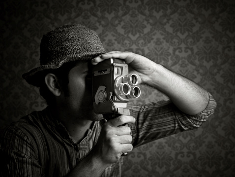 Man using old fashioned cine camera, black and white image