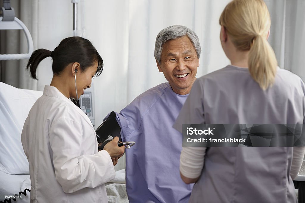 Médicos analizar hombre senior paciente - Foto de stock de 20 a 29 años libre de derechos