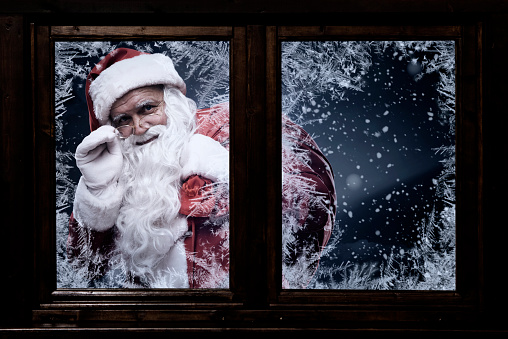 Traditional Santa Claus looking through the window