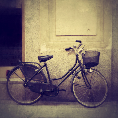 Vintage old bicycle against the wall in an iconic street of Cambridge