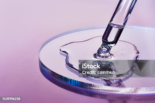 istock Pipette with sample of cosmetic product in petri dish on holographic background, iridescent highlights, selective focus 1439196228