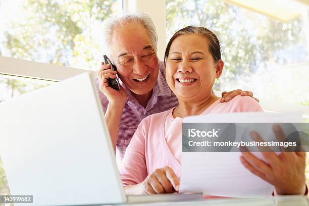 Taiwanés Senior Pareja Trabajando En Casa Foto de stock y más banco de imágenes de Tercera edad - Tercera edad, Usar el teléfono, Documento