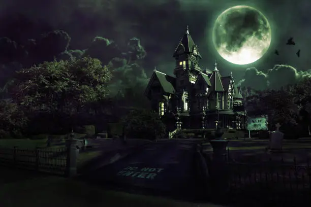 Dark image of a haunted house with clouds and mountains in the background. Includes graveyard, full moon, and crows flying across moon. Copy space. CLICK FOR SIMILAR IMAGES AND LIGHTBOX WITH SEASONAL IMAGES.