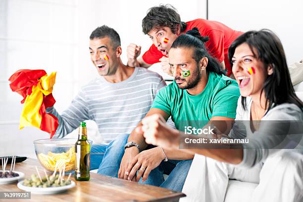 Rival Soccer Team Fans Cheering In Living Room Stock Photo - Download Image Now - Television Industry, Television Set, Soccer