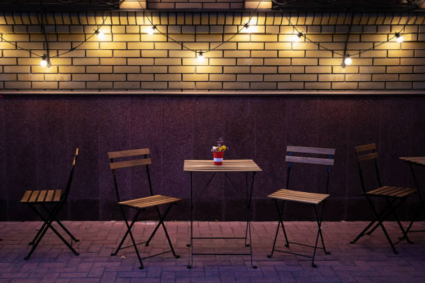 istock Cafe tables and chairs on the sidewalk in the evening 1439198677