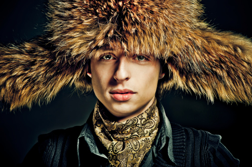 Young man wearing furry winter hat.