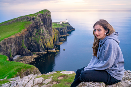 Blond girl student tourist in Skye island Nest Point lighthouse in Highlands Scotland UK in United Kingdom