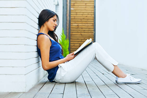 istock Young woman reading a book 143919880