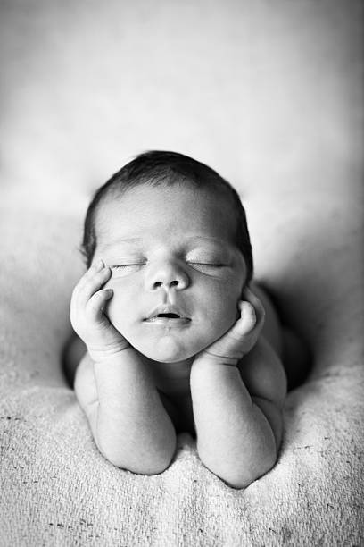 istock Newborn Baby Boy Sleeping Peacefully with Head in Hands 143920016