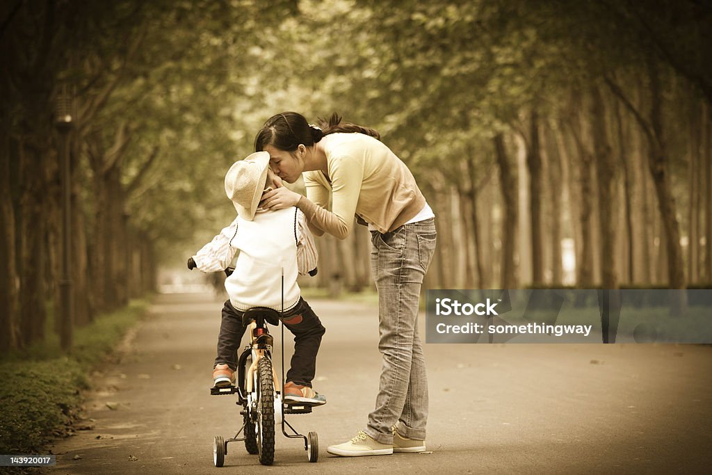 Mamma insegna figlio nel parco bicicletta - Foto stock royalty-free di Bicicletta