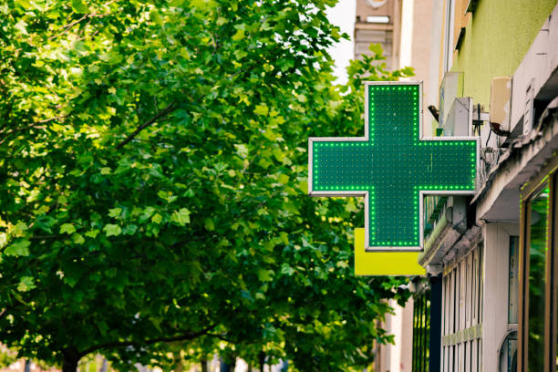 Green pharmacy cross in town stock photo