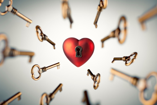Single red padlock with heart on it connected to a chain, brown blurred background, horizontal
