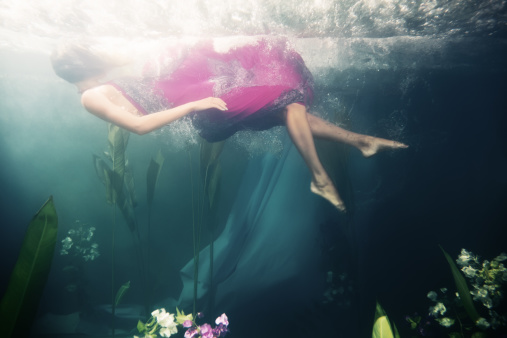 Woman drowns in the ocean and calls for help. A girl in a dress under water