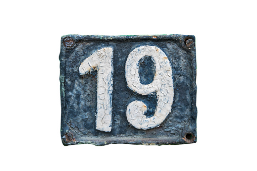 Old retro weathered cast iron plate with number 19 closeup isolated on white background