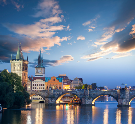 landscape with Vltava river, Charles Bridge and boat in the evening in autumn in Prague, Czech Republic.