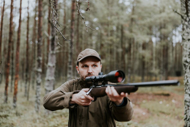 istock Hunter aiming with hunting rifle in the autumn forest 1439202036