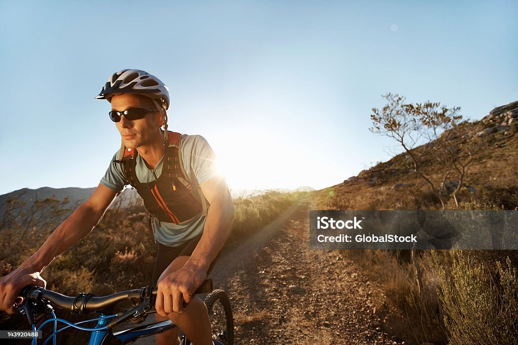 Man riding mountain bike on gravel path - Стоковые фото 30-39 лет роялти-фри