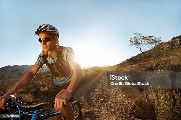 Man Riding Mountain Bike On Gravel Path — стоковые фотографии и другие картинки 30-39 лет - 30-39 лет, Велосипедная дорожка - спорт на открытом воздухе, Велосипедный шлем