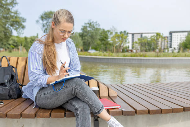 istock Young woman sitting outdoors and studying 1439205374