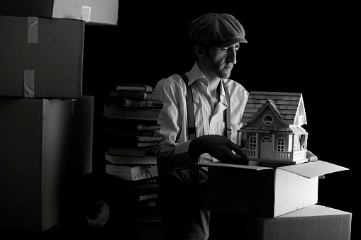 Black and white portrait of man packing home for relocation