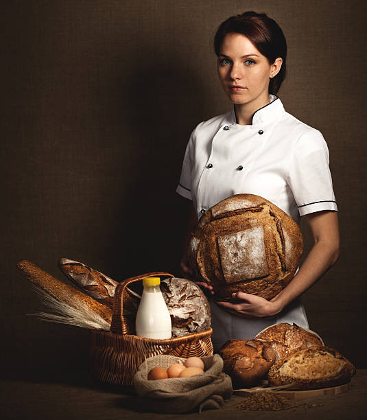 Baker holding in hands fresh baked bread.