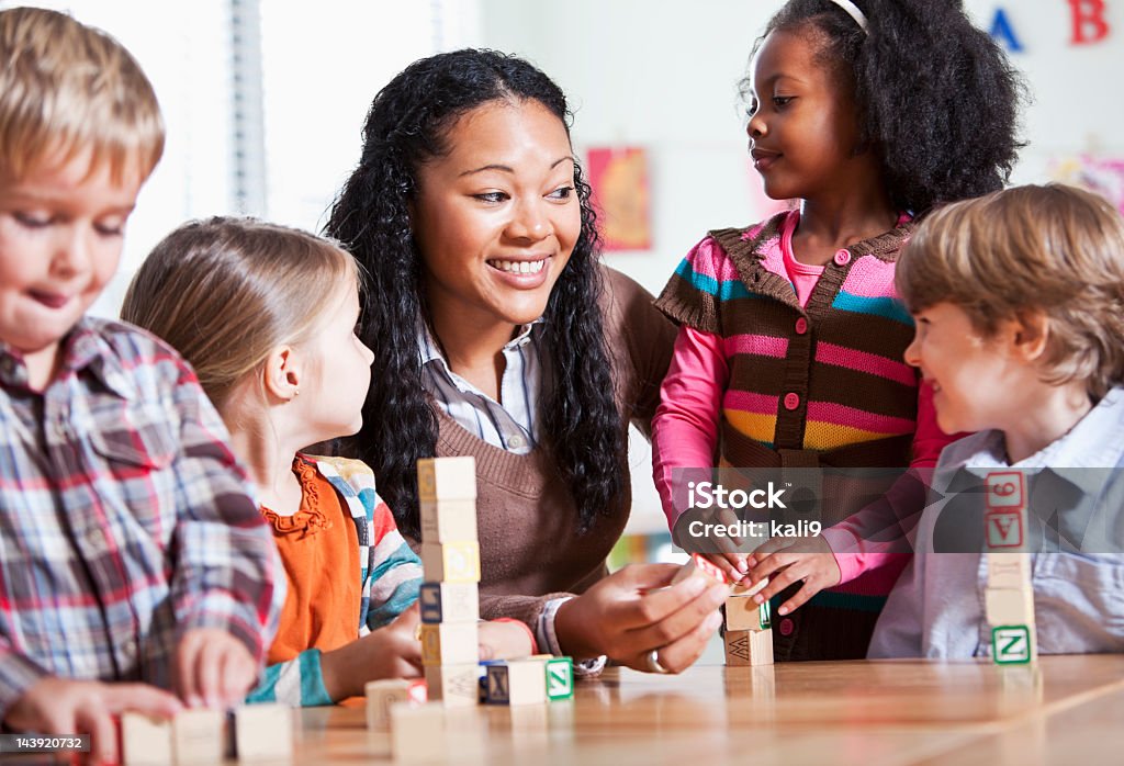 Pequenas, crianças em sala de aula com o professor - Foto de stock de Cuidar de crianças royalty-free