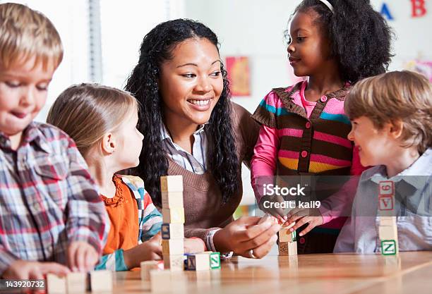 Foto de Pequenas Crianças Em Sala De Aula Com O Professor e mais fotos de stock de Cuidar de crianças - Cuidar de crianças, Professor, O Alfabeto