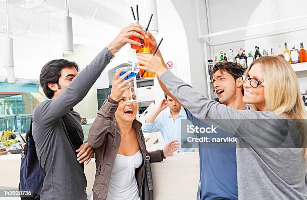 Jóvenes Amigos Celebrar En El Bar Foto de stock y más banco de imágenes de Adulto - Adulto, Adulto joven, Alcoholismo