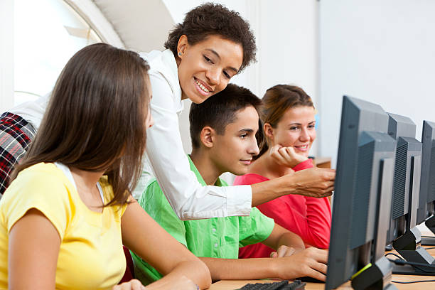 professor com os alunos trabalhando em computadores na sala de aula - apple for the teacher imagens e fotografias de stock