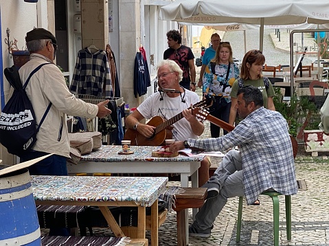 LAGOS,  Portugal - October 20,  2022. People enjoy the performance of street musicians in the city of Lagos.