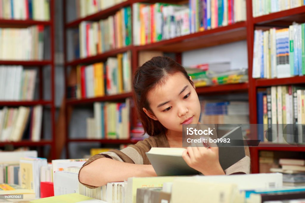 Hübsche student lesen Buch in Bibliothek - Lizenzfrei Buchhandlung Stock-Foto