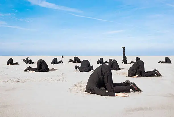 Lots of business man hiding their heads in sand. XXL size image.