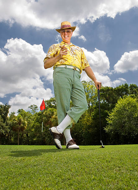 Golfer dressed in funny golf outfit with cigar stock photo