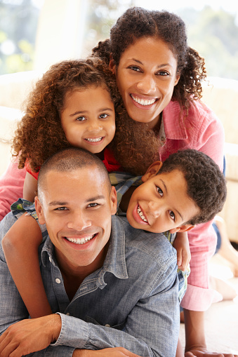 Mixed race family at home smiling at camera
