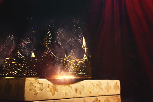 low key image of beautiful queen or king crown over wooden table. vintage filtered. fantasy medieval period