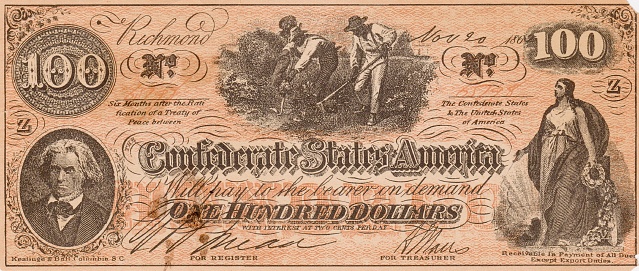 One hundred dollar Confederate States of America bill, November 20, 1862, with 7th US Vice President John C. Calhoun, a Classical woman, and slaves working in an agricultural field. Close-up. Bill published November 20, 1862. Original edition is from my own archives. Copyright has expired and is in Public Domain.