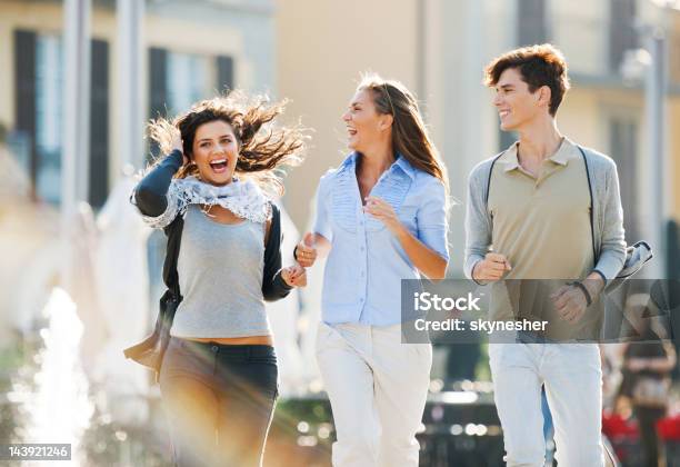 Tres Amigos Corriendo Por Las Calles De La Ciudad Foto de stock y más banco de imágenes de Actividad - Actividad, Actividad física, Actividades recreativas