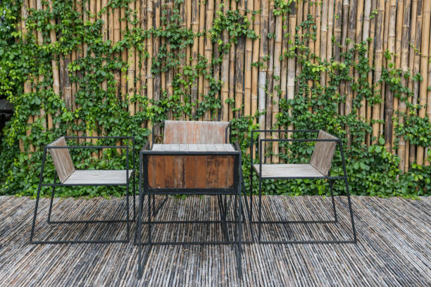 istock Table and chairs on bamboo floor and wall with ivy climber tree 1439213656