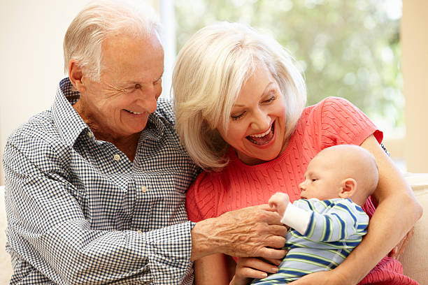 Senior couple with baby grandson Senior couple with baby grandson playing and smiling old man baby stock pictures, royalty-free photos & images