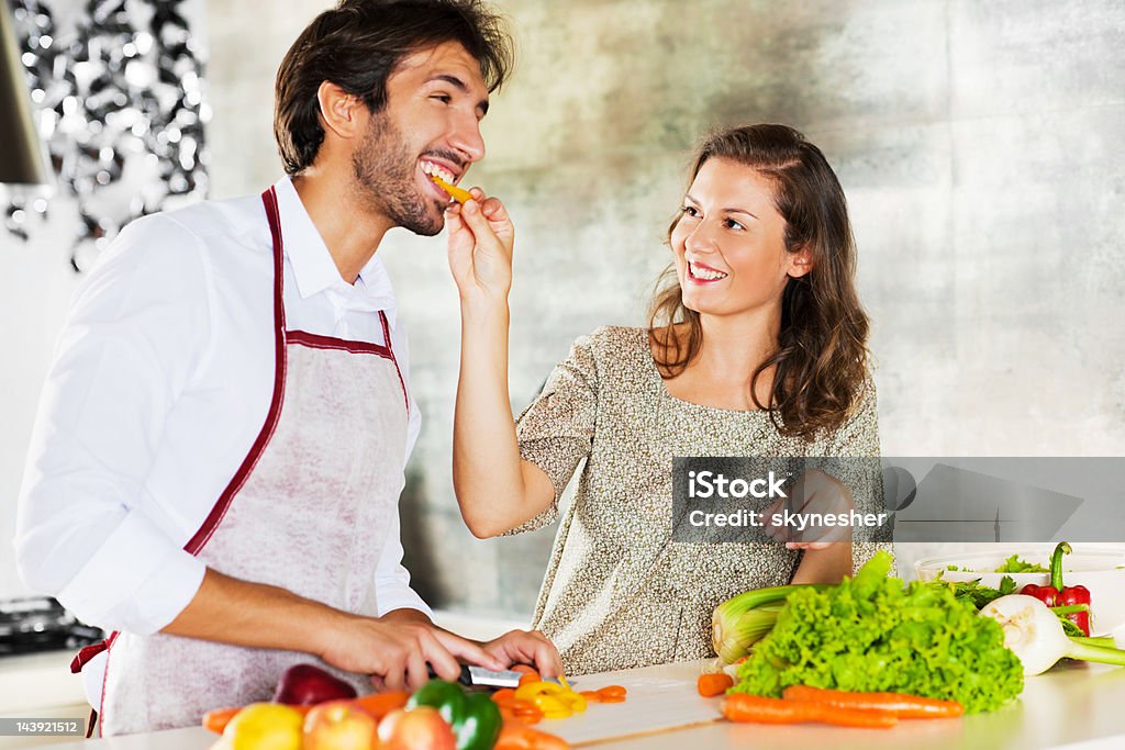 Portret Uśmiechający się para przygotowuje obiad razem. - Zbiór zdjęć royalty-free (Karmić)