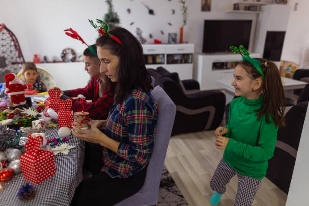 istock Happy family decorates Christmas tree 1439215395