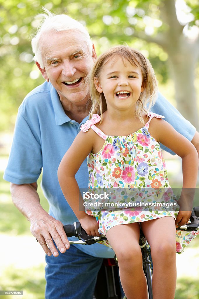 Senior man riding bike con granddaughter - Foto de stock de Abuelo libre de derechos