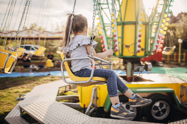 istock Little girl on chain swing ride 1439217294