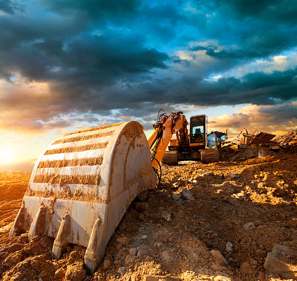 istock Excavator at a construction site against the setting sun 143921761